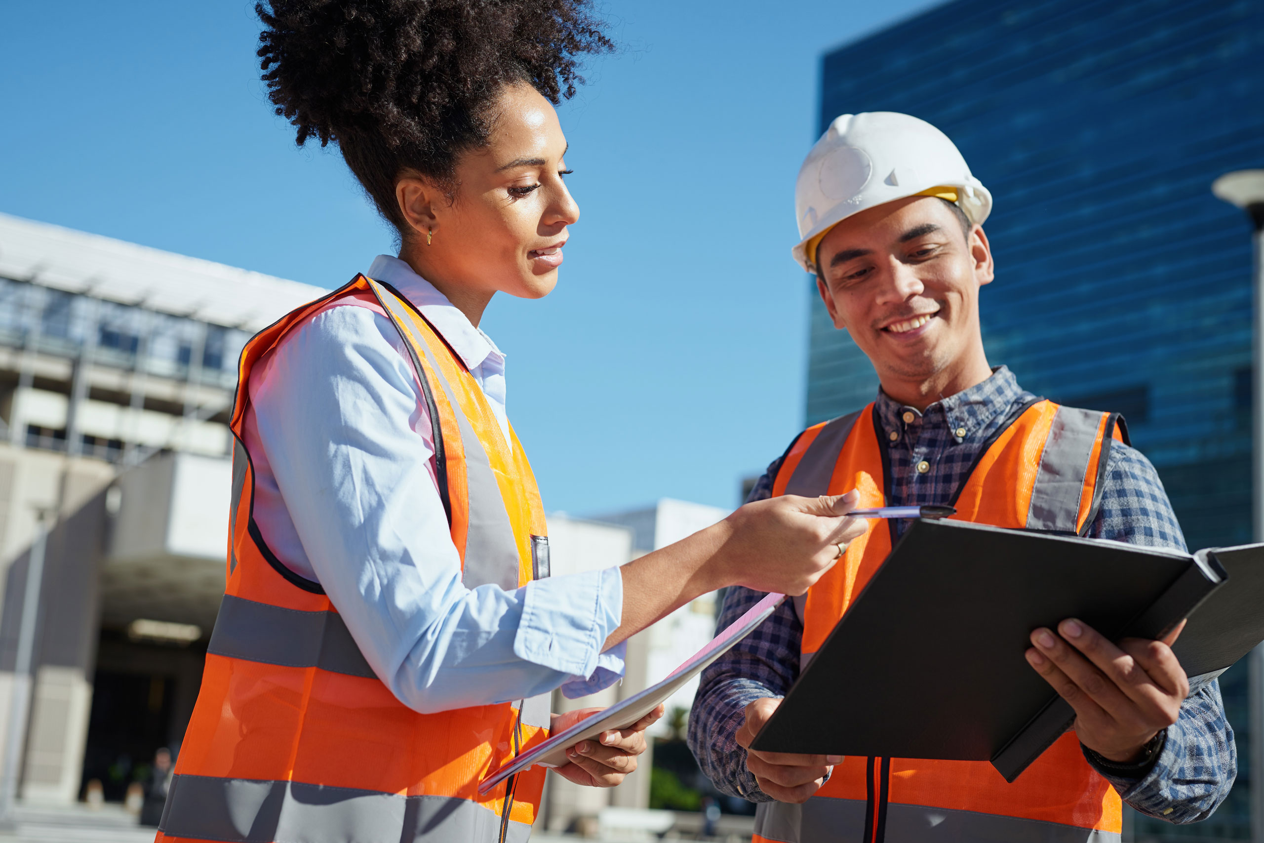 Diverse Construction Workers Collaborating on Outdoor Building Project