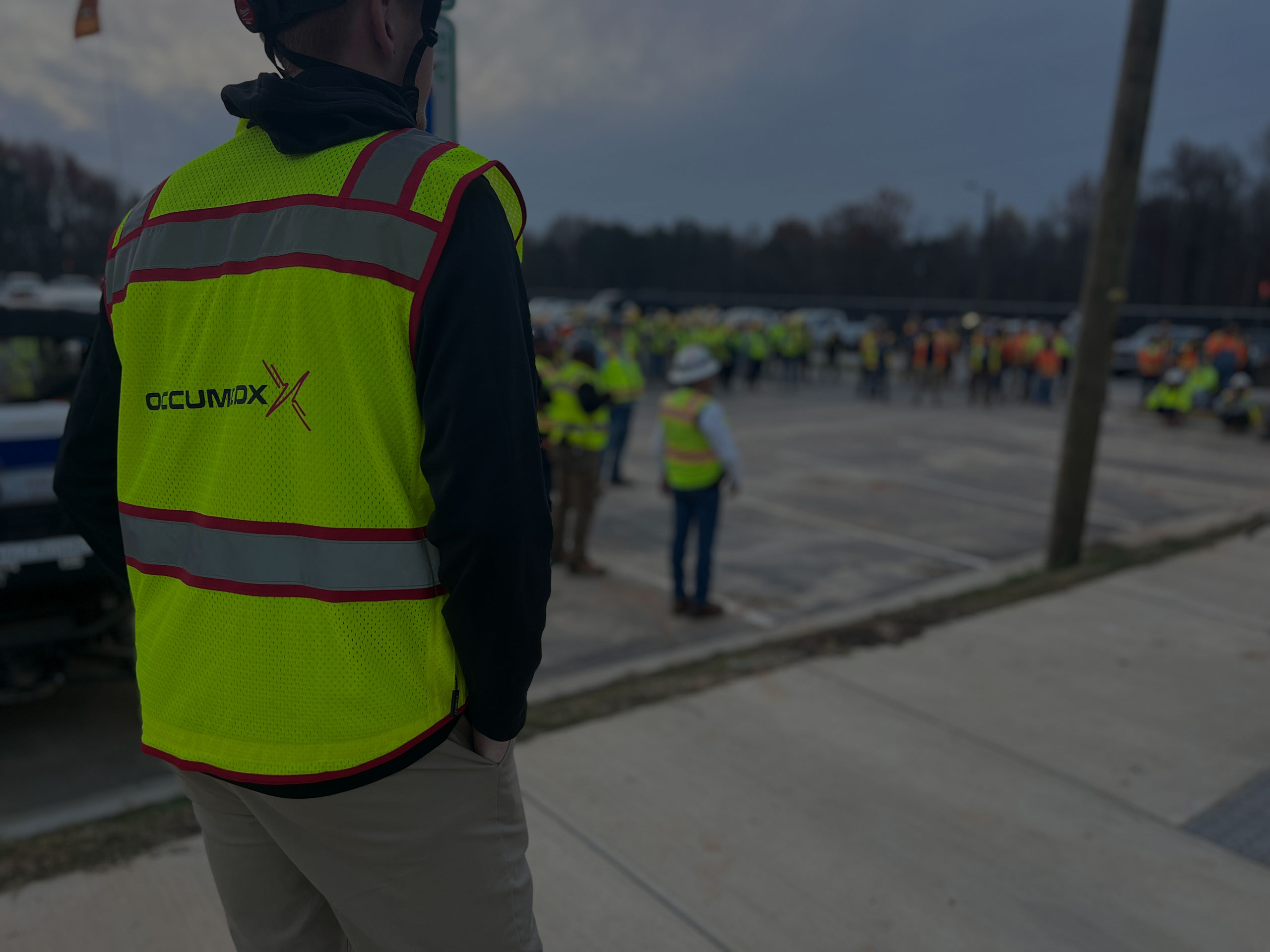 OccuMedX employee standing overseeing a large workers group outside
